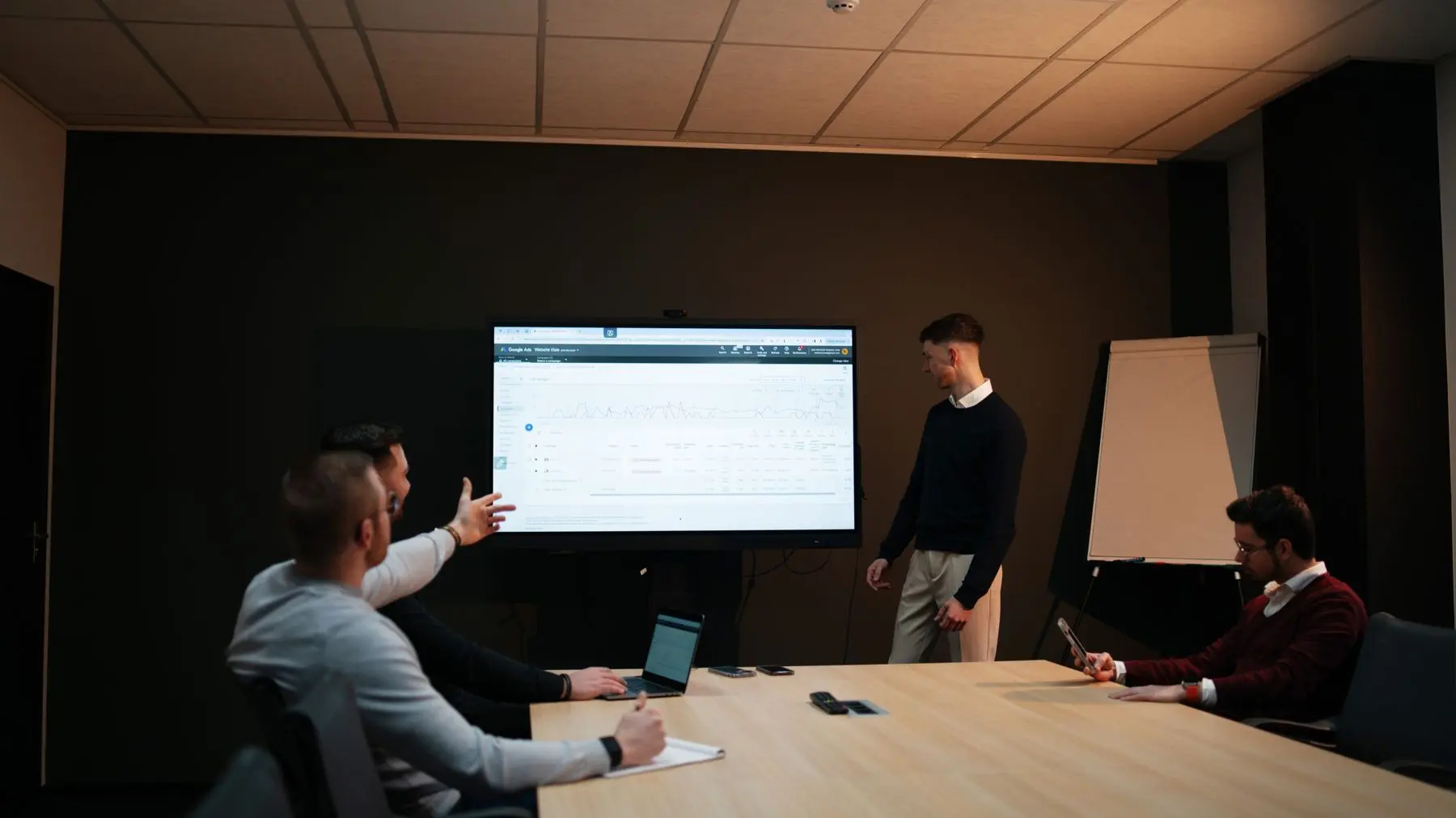 Een websiteontwerp wordt op een groot scherm besproken aan tafel